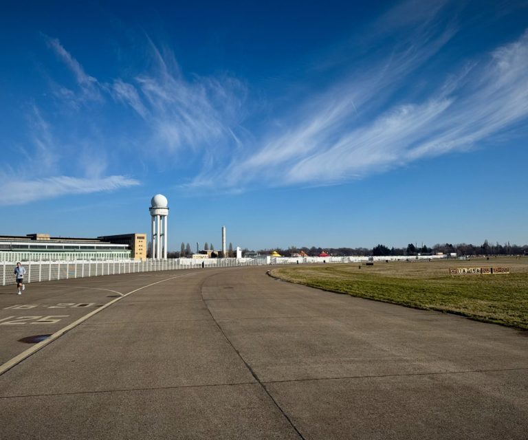 Luftbild eines Flughafens mit klarer Himmel und gepflasterter Landebahn.